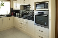 creme kitchen with black tile splashback
